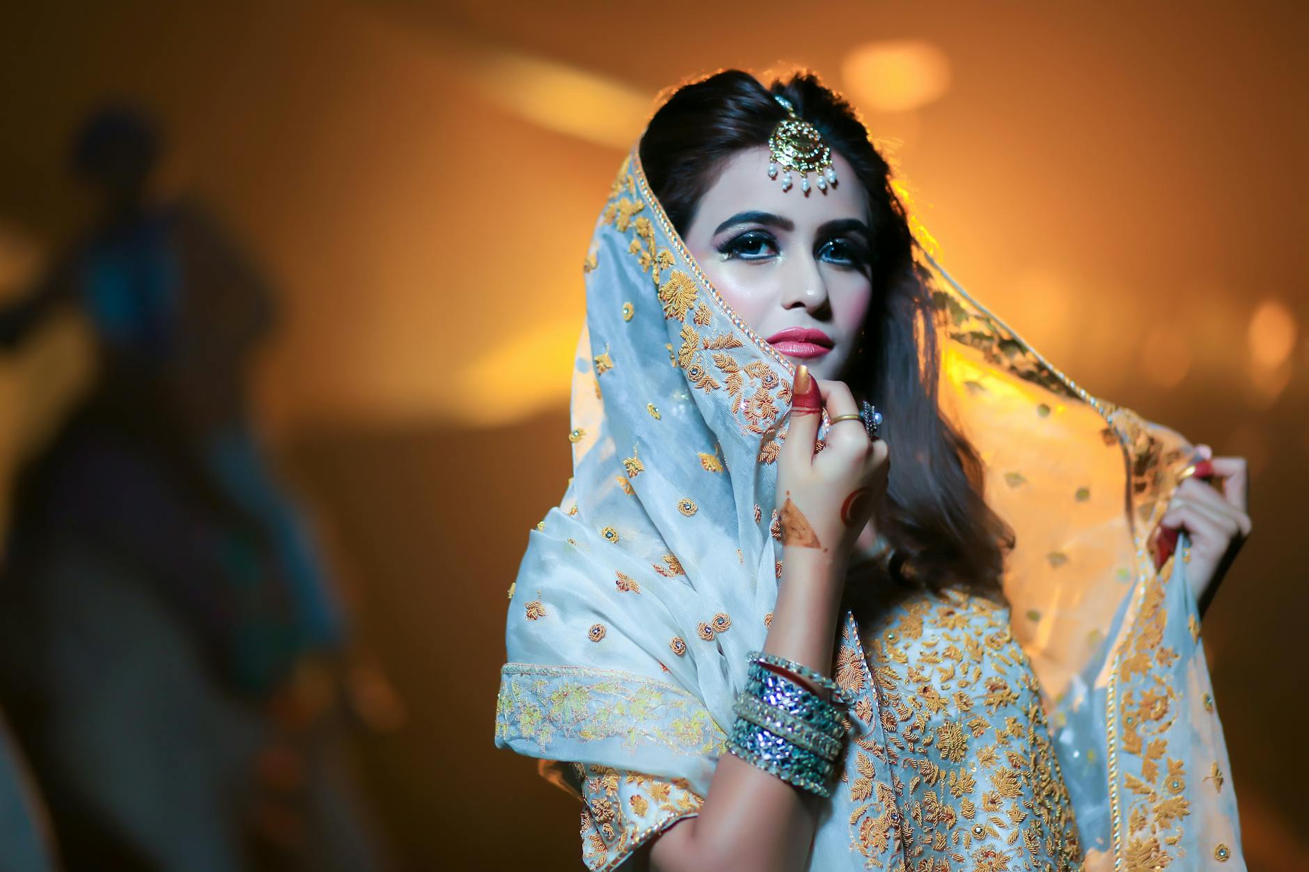 shallow focus photography of woman wearing blue and gold dress